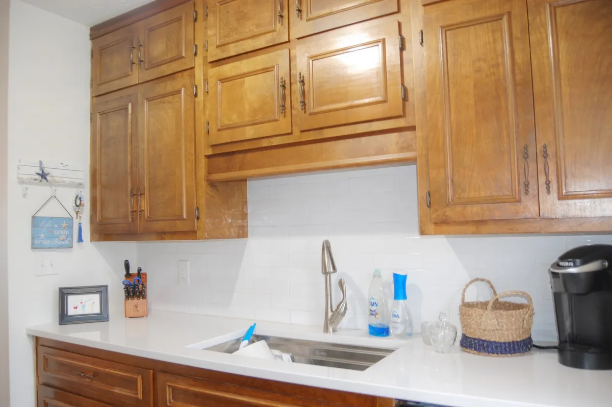 A bright and functional kitchen area with wooden cabinets, gleaming white countertops, a spacious sink, and a convenient coffee maker. The scene is styled to evoke everyday comfort, making it perfect for both casual breakfasts and elaborate feasts. The setup encourages shared moments and easy entertaining.